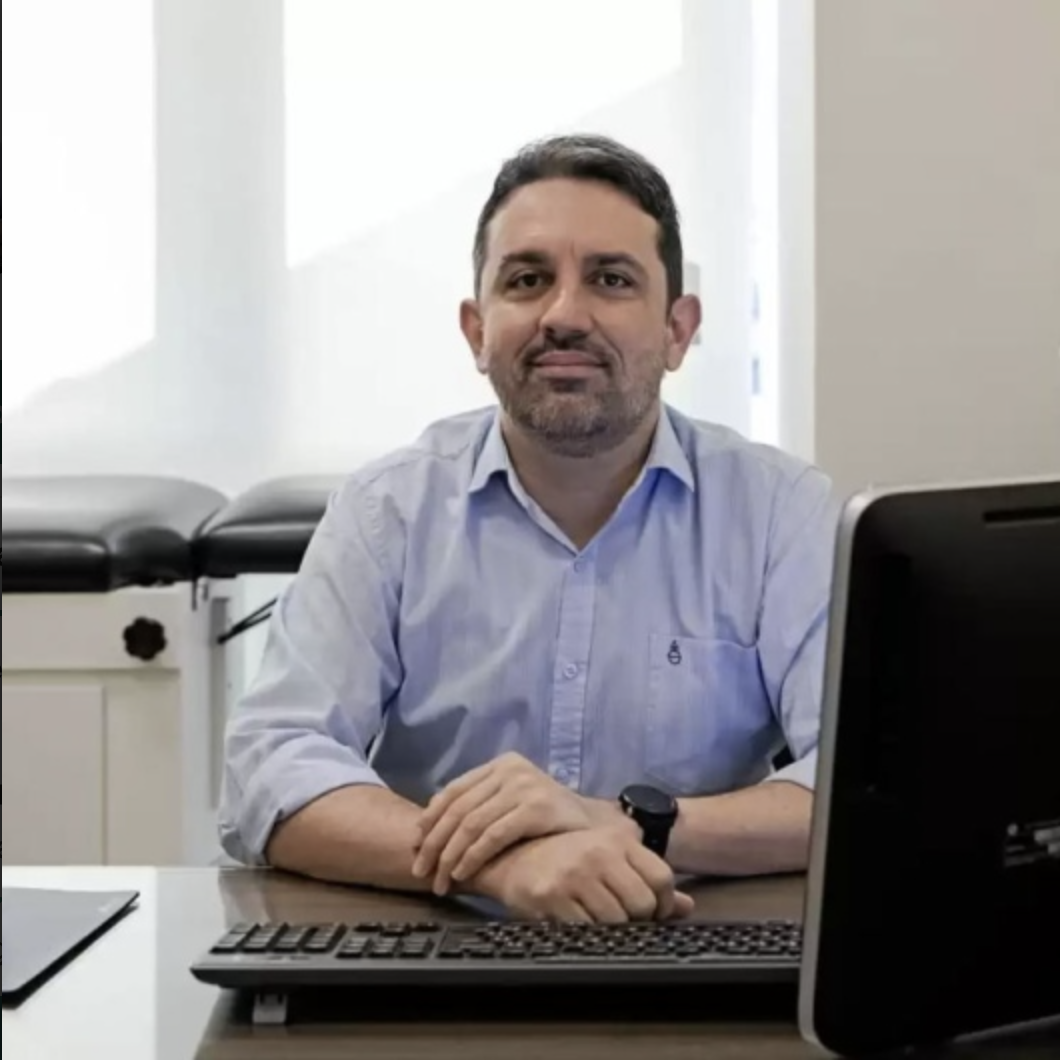 Dr. Wilton Santana sentado em seu consultório